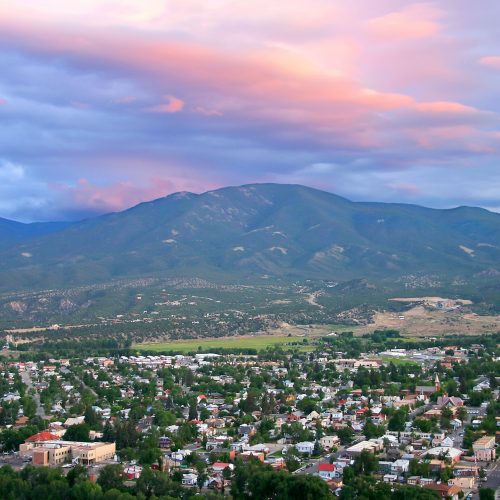 Aerial view of Salida Colorado, with beautiful pink sunset cloud overhead and mountain range in background. Chaffee County.